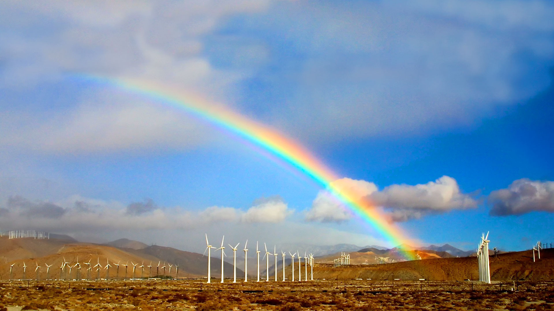 Rainbow over arching a wind farm as a Blury Background